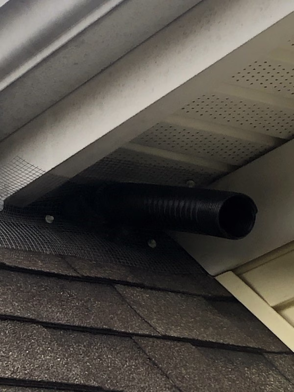 Discreet bat cone exclusion device resembling vacuum hose installed under dormer soffit for low-profile wildlife removal